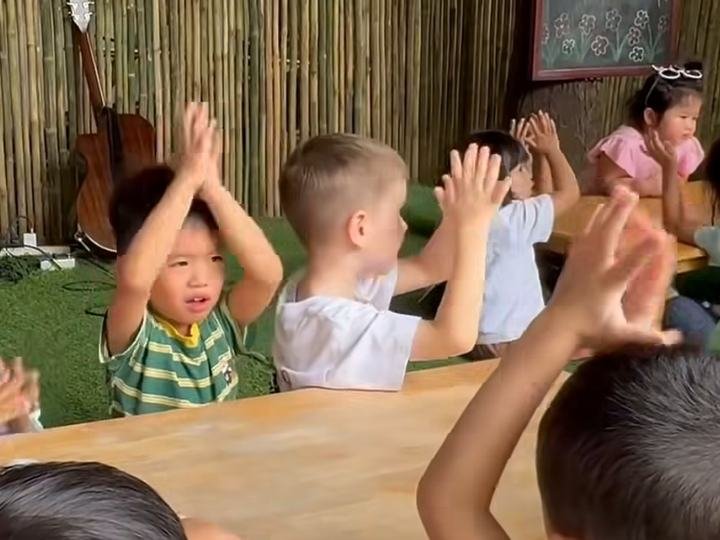 Children raising their hands above their heads