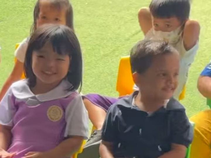 Smiling children seated on small chairs