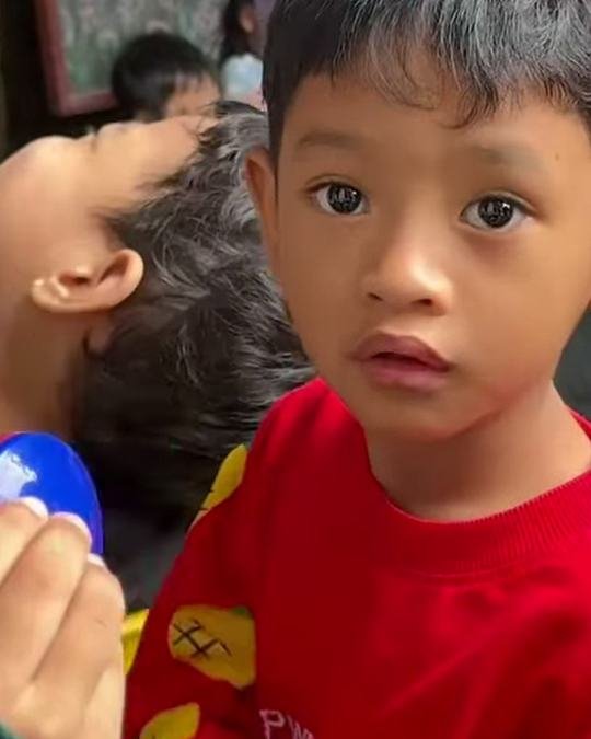 Boy in a red sweater holding a castanet