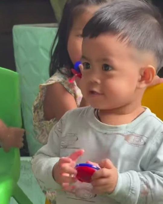 Toddler holding a castanet and smiling